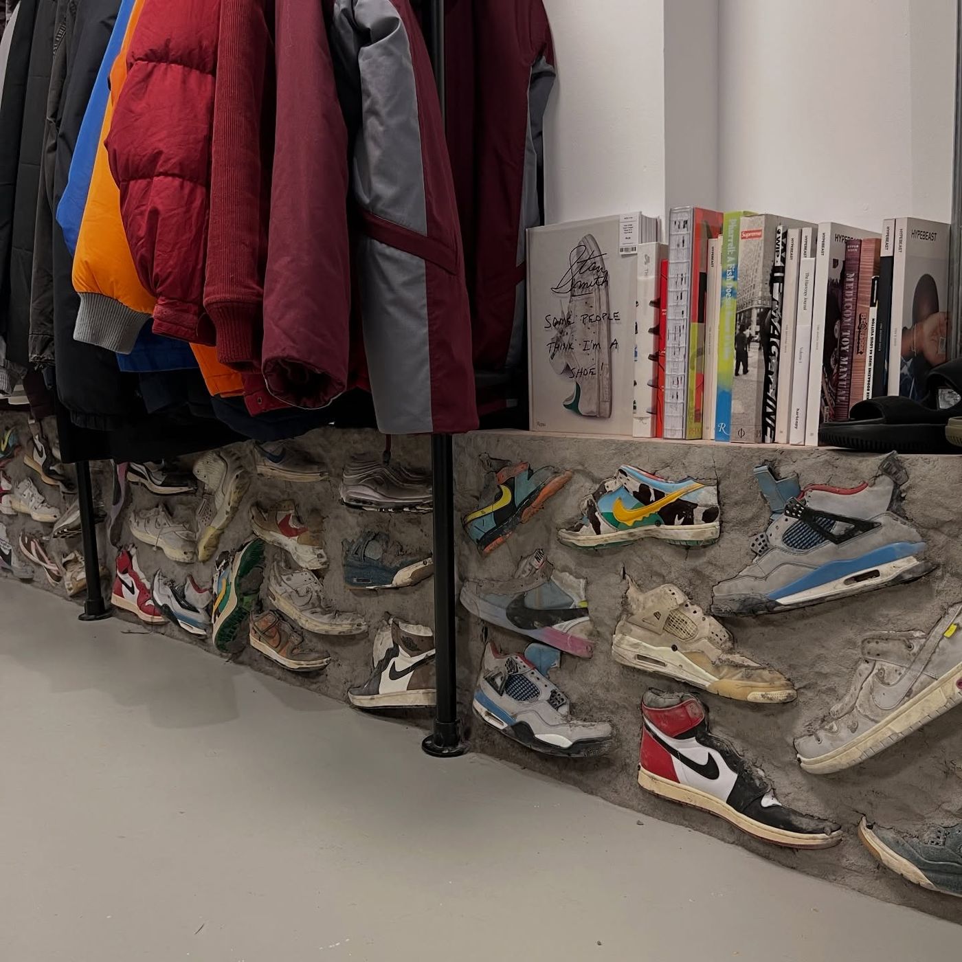 Concrete wall embedded with sneakers at the Haarlemmerdijk store