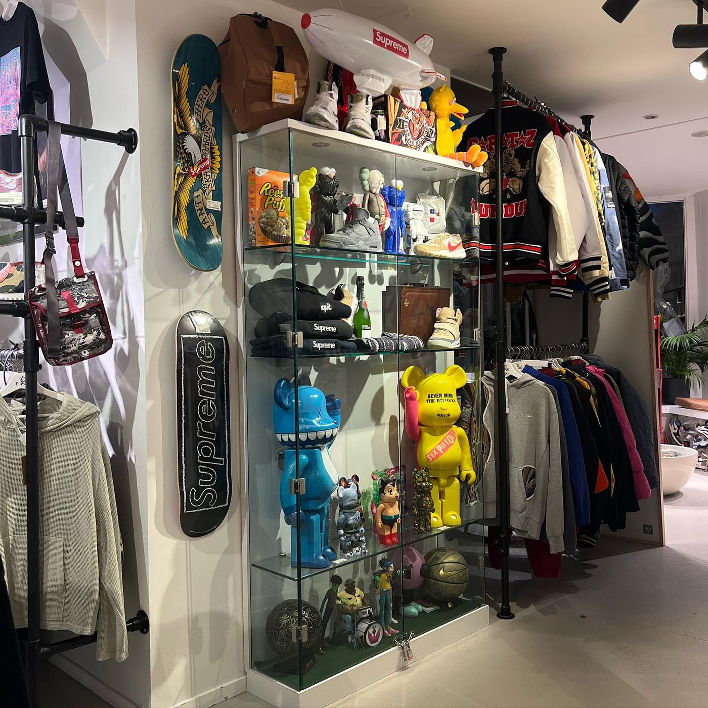 Display case with Supreme collectibles and figures